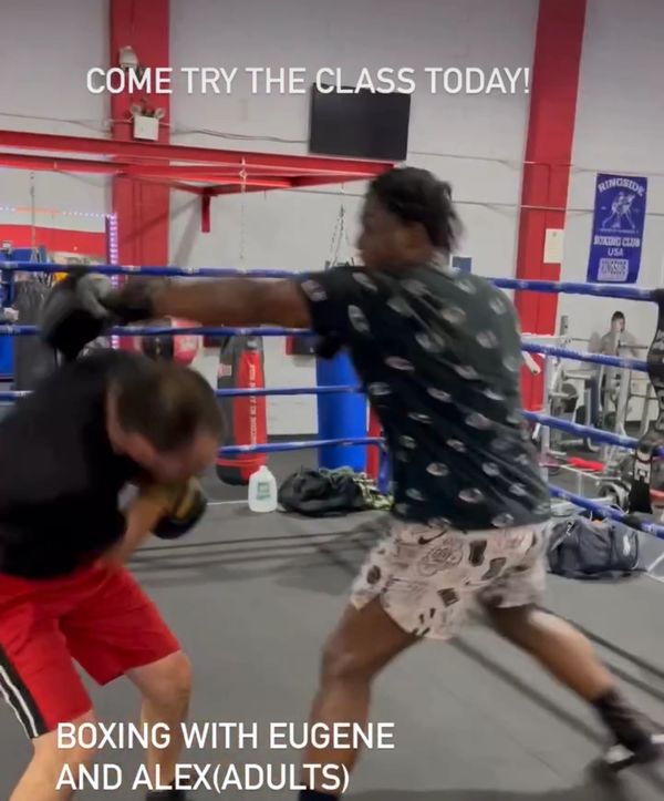 Two men boxing in a gym ring promoting adult boxing classes.