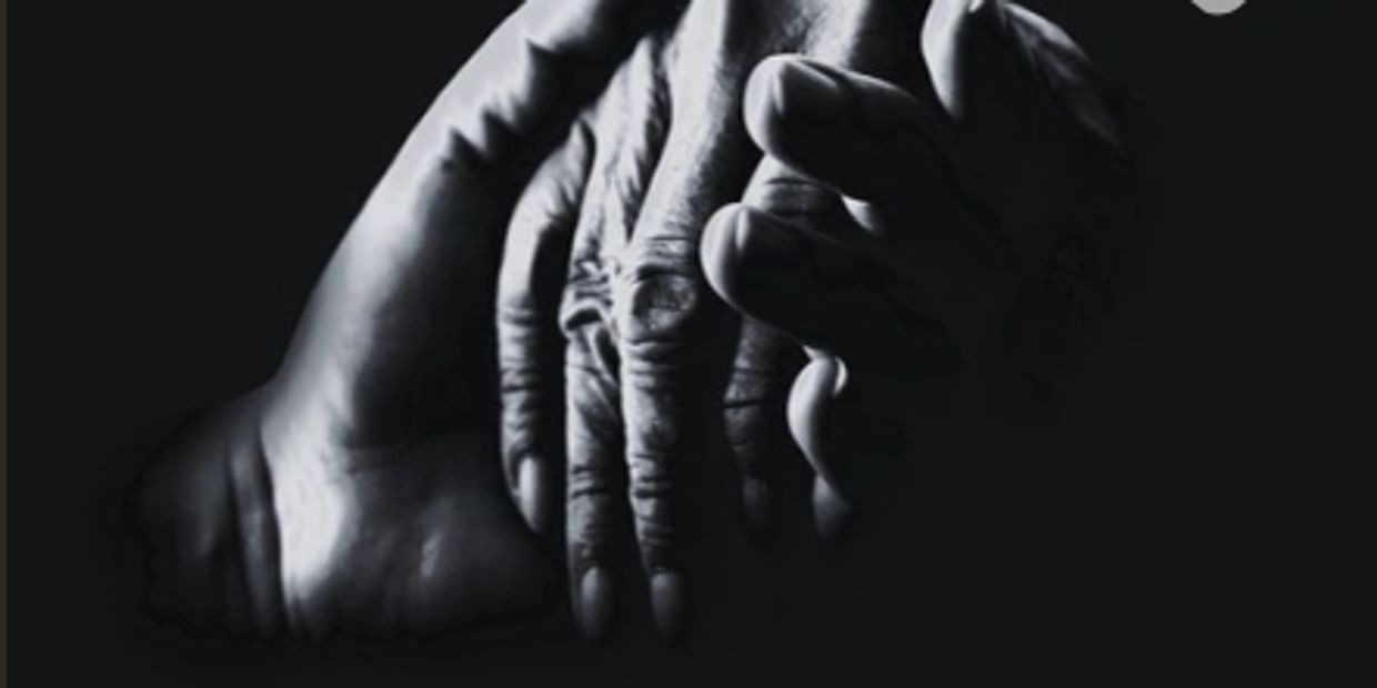 Two hands gently holding each other in a black and white close-up.
