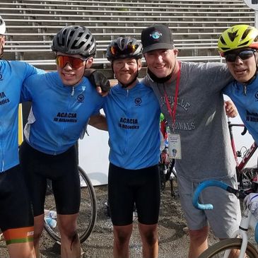 Cyclists and coach posing happily at a cycling event.