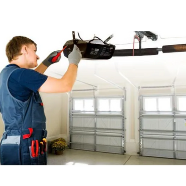 Technician repairing a garage door opener with tools.