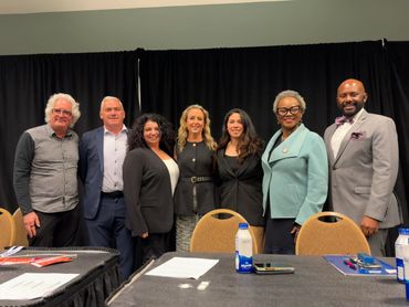 Panel of speakers at coalition event discussing safe driver incentives. A group of people lined up