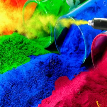 Brightly colored powders spilled from cups with yellow powder sprayed.