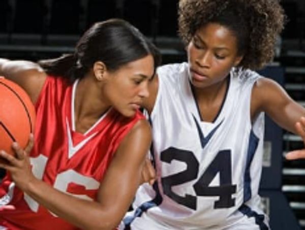 Two female basketball players competing intensely during a game.