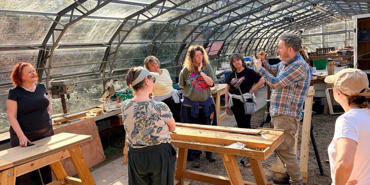 Group workshop taking place in a greenhouse workshop.