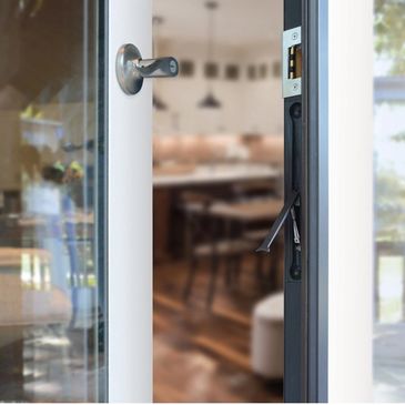 Partially open glass door leading to a cozy indoor room.