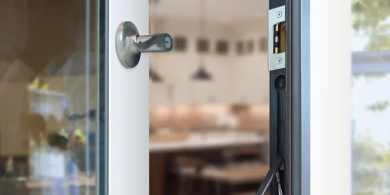 Partially open glass door with a modern handle.