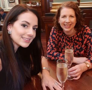 two smiling women wearing hats and drinking prosecco
