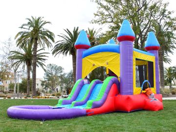 Colorful inflatable bounce house with slides in a park.