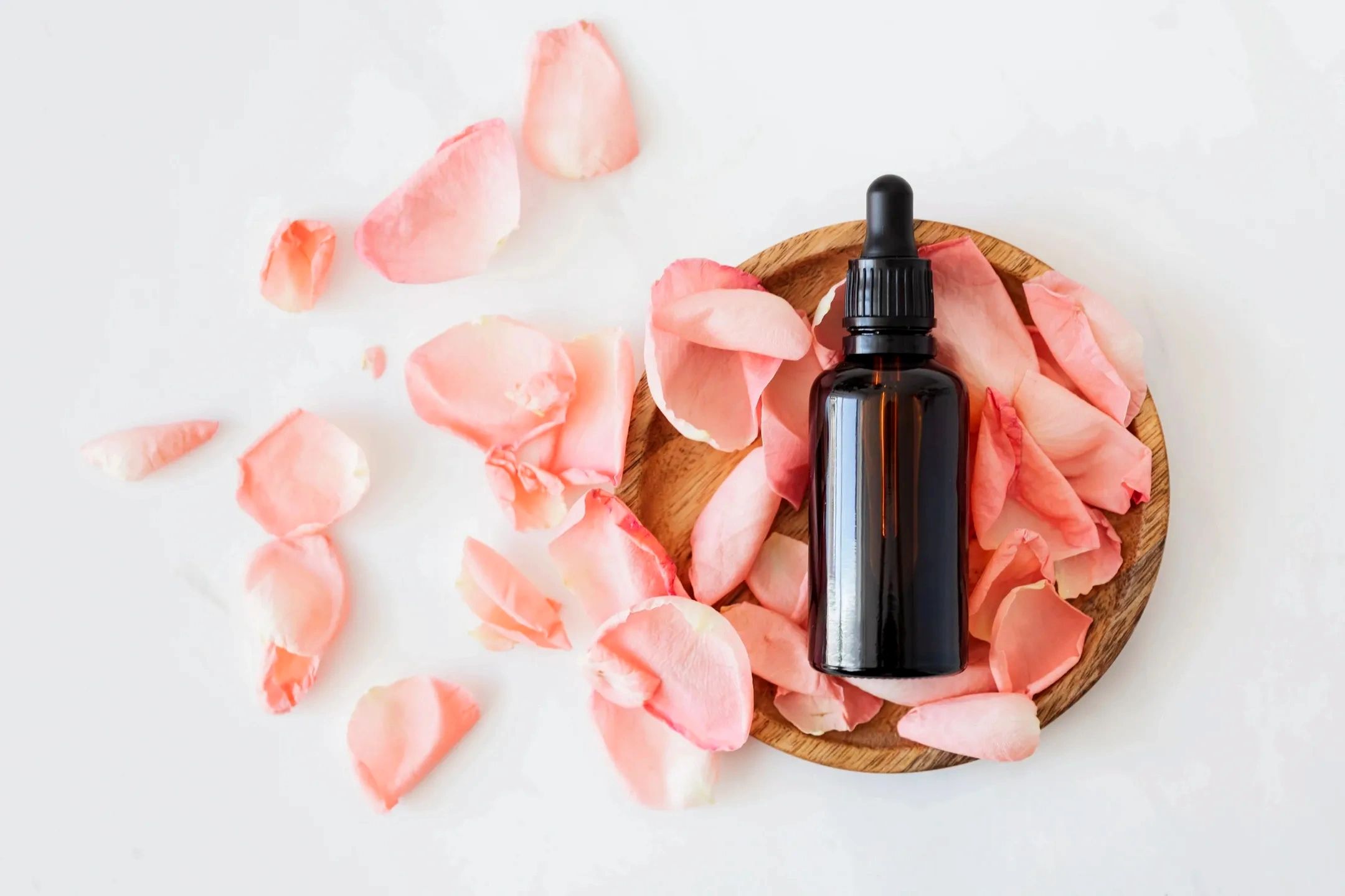 Specialty face oil surrounded by rose petals.
