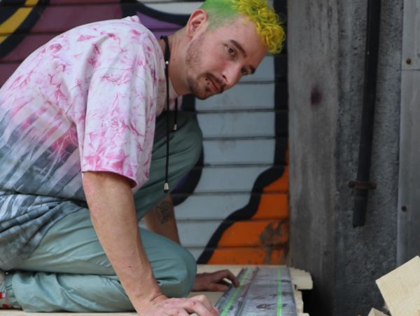 A woodworker with brightly colored hair using a festool tracksaw.