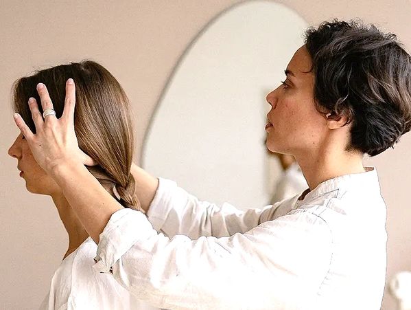 A person styling another's hair in a calm, indoor setting.