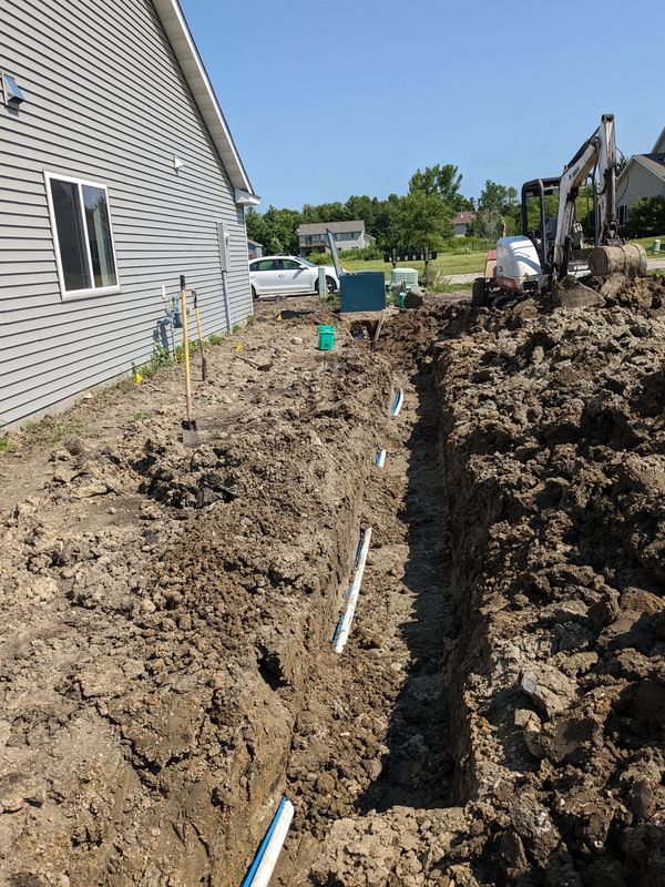 A house with dirt and pipes in the ground.