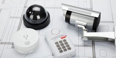 Various security devices placed on architectural blueprints.