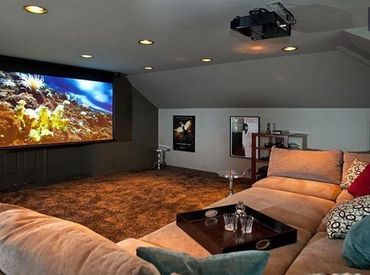 Cozy home theater with large sectional sofa and projector screen.