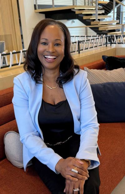 Smiling woman sitting on a couch indoors.