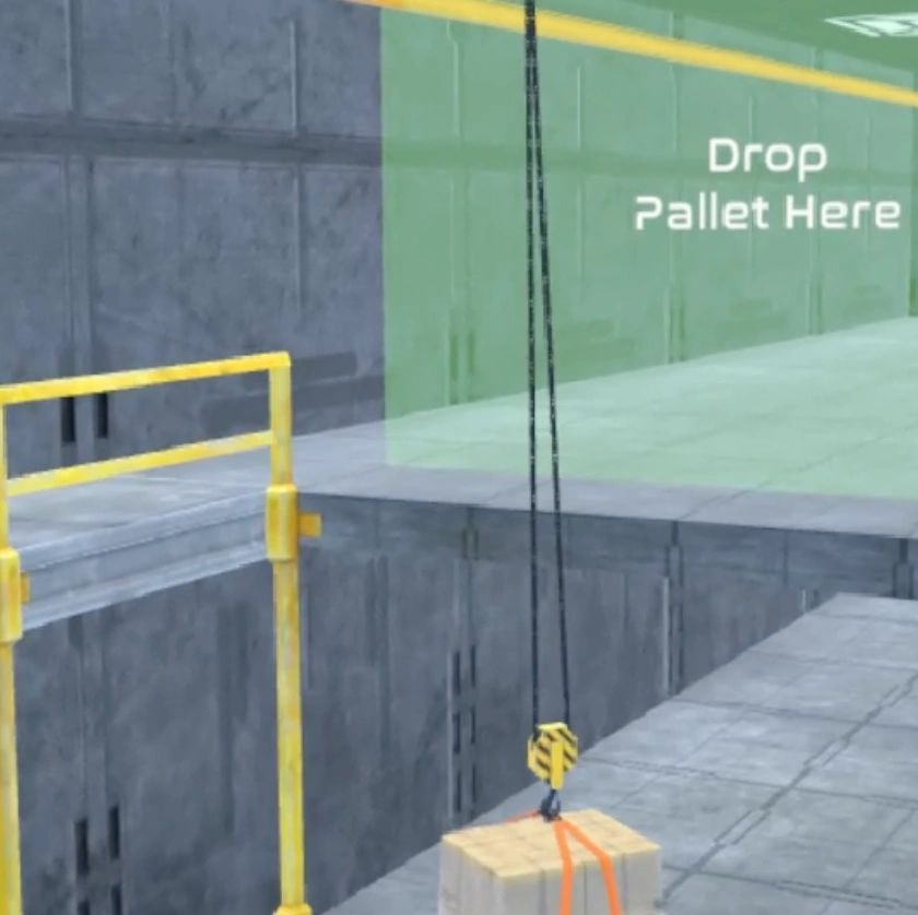A crane hoisting a pallet labeled 'Drop Pallet Here'