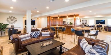 Spacious lounge with leather sofas, wooden tables, and modern lighting.