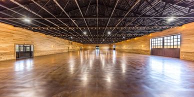 Spacious empty hall with wooden walls and string lights on the ceiling.
