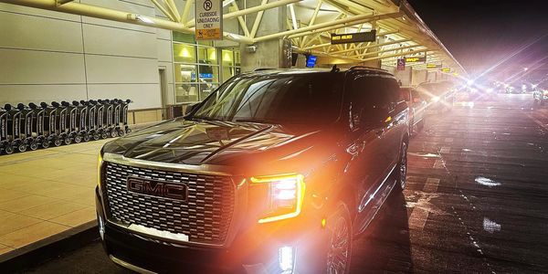 Black Clover Transportation| Black Car Services SUV at Orlando International Airport Terminal