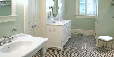 pale green bathroom multiple white sinks and vanities black and white classic tile floor