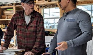 two men discussing design agreement while studying blueprint