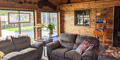 wood paneled four season room with large windows and comfortable seating