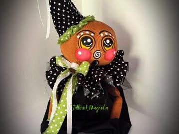 Handmade gingerbread doll wearing a black polka-dot outfit.