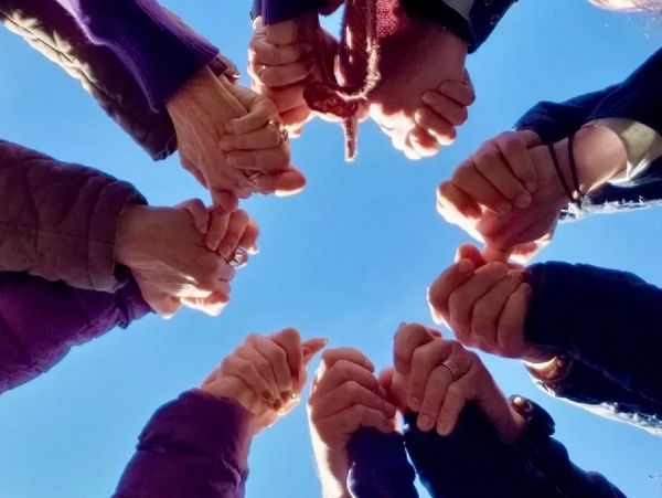 Group of people holding hands in a circle 