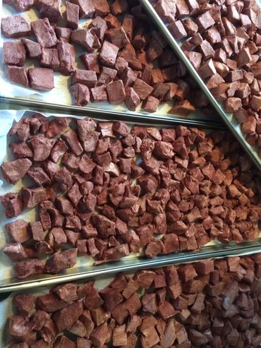 Trays filled with uniformly cut brown chunks, possibly meat or food pieces.