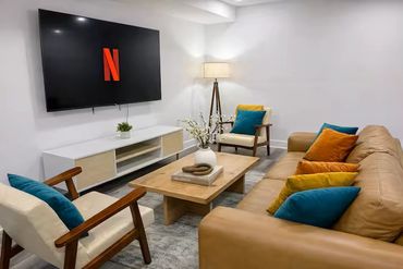 Cozy living room with a mounted TV and colorful cushions.