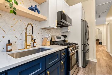 Modern kitchen with blue lower cabinets and white upper cabinets.