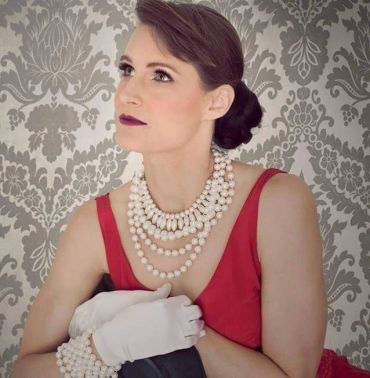 Elegant woman in a red dress with pearl jewelry.