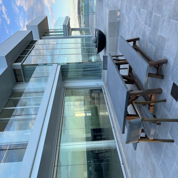 Modern outdoor patio with sleek furniture and glass balcony.