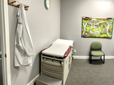 The room features a comfortable exam table with a paper cover, ready for for the next patient.