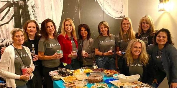 Group of women wearing matching FRIENDS shirts at a party.