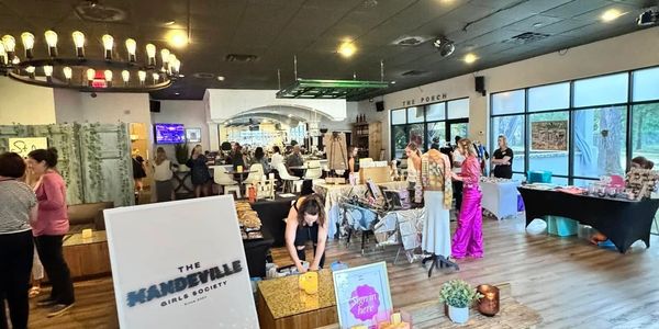 Indoor market event with people browsing stalls and displays.