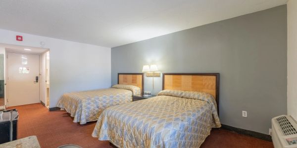 Hotel room with two beds and neutral decor.