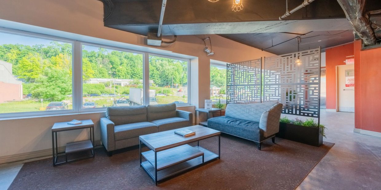 Modern lounge area with large windows and stylish furniture.