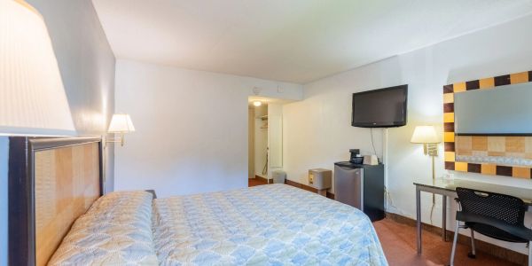 Simple hotel room with a large bed and basic amenities.