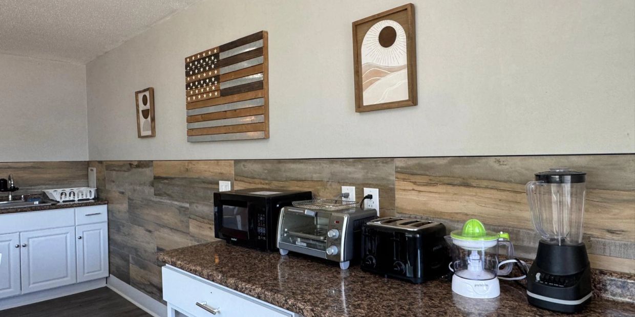 Kitchen countertop with appliances and wall art.