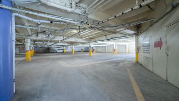 Empty indoor parking garage with one car.