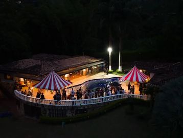 Fiesta nocturna al aire libre con carpas y piscina.