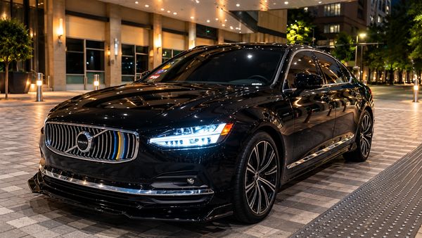 Sleek black Volvo car parked at night in the city of Houston Tx