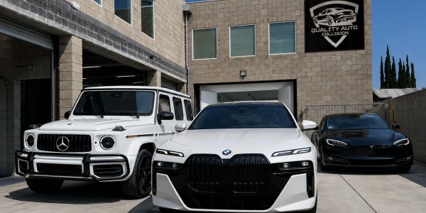 Three luxury cars parked outside Quality Auto Collision shop.