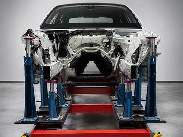 Car frame mounted on a vehicle alignment machine.