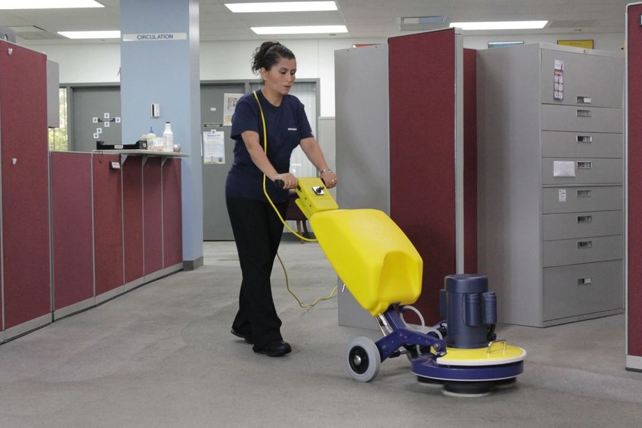 Woman using a low moisture carpet cleaning machine to clean commercial carpeting in san angelo, tx.