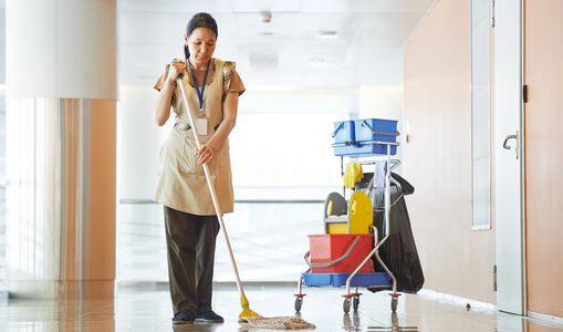 Woman mopping the floor of a commercial cleaning account.