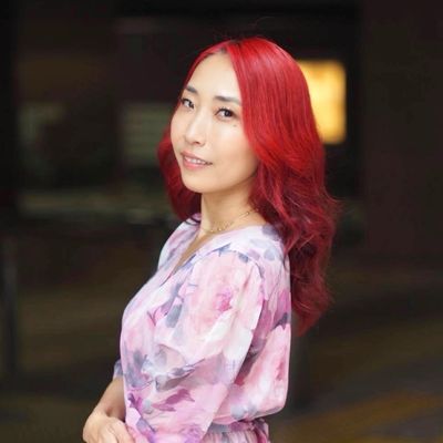 赤い髪の女性が微笑んでいる。