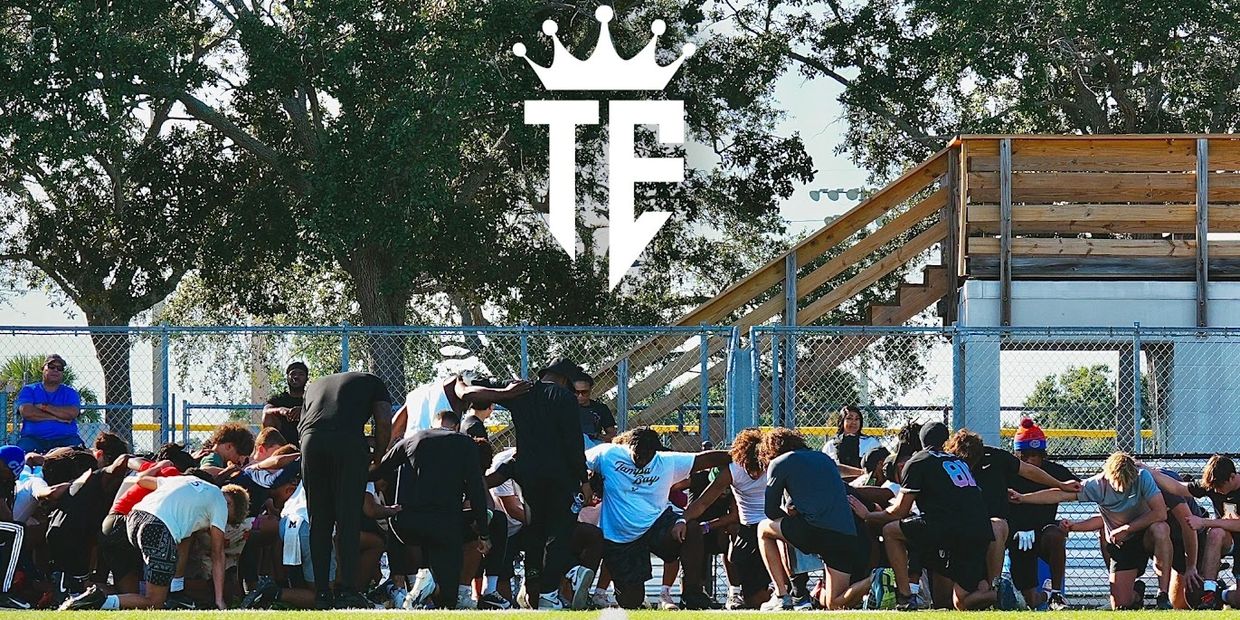 Group of athletes kneeling together in solidarity on a field.
