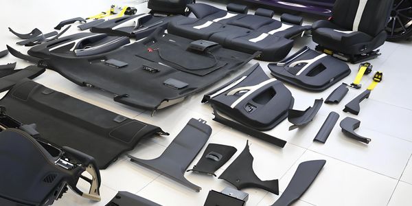 Disassembled car interior parts laid out on the floor.